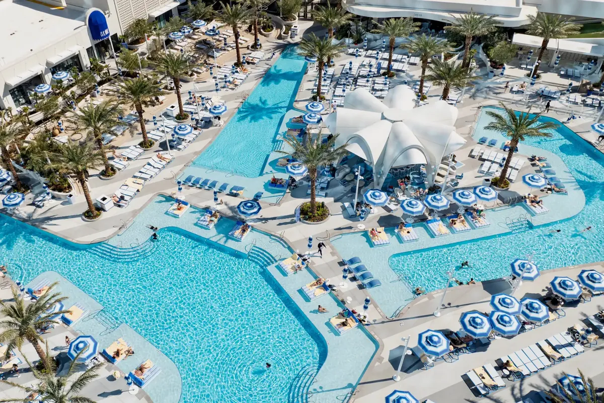 Aerial view of the Fontainebleau Las Vegas pool deck with blue umbrellas and palm trees