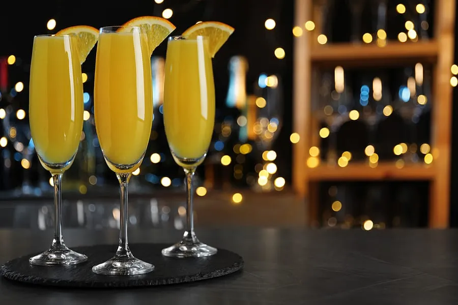 mimosa cocktail with garnish on bar counter against blurred ligh
