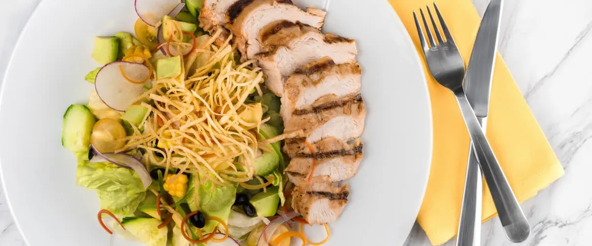 Salad with grilled chicken, corn and cheese.